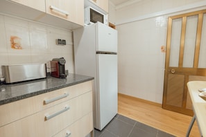 Eine Küche mit einem Toaster, einer Kaffeemaschine und einem Kühlschrank.