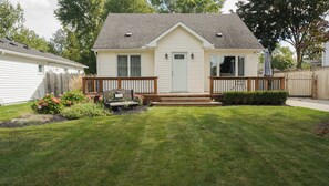 A single-story house with a front porch, a small deck, and a well-maintained lawn. - The Beach House - Deeded Beach Access (Brights Grove)