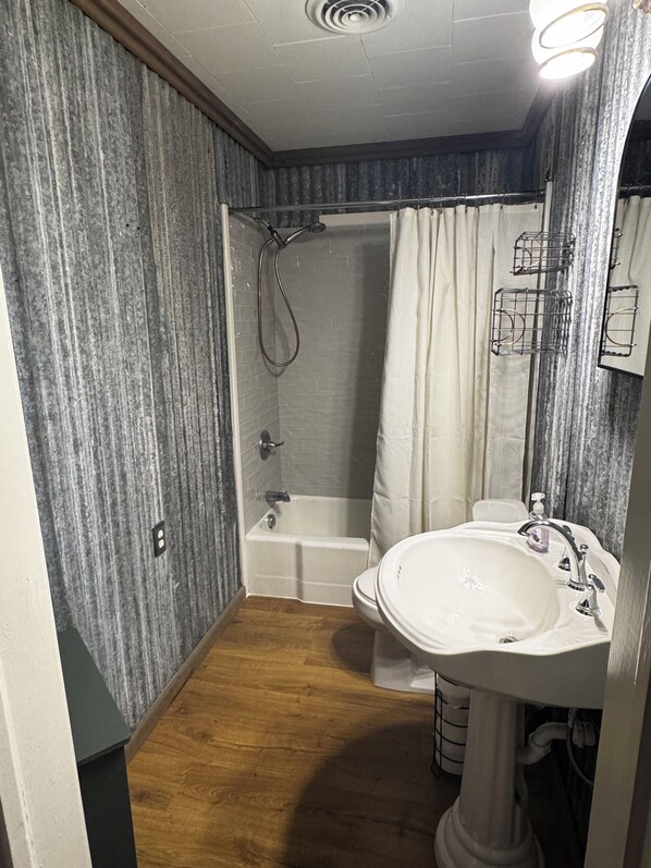 A bathroom with a shower, bathtub, and sink.