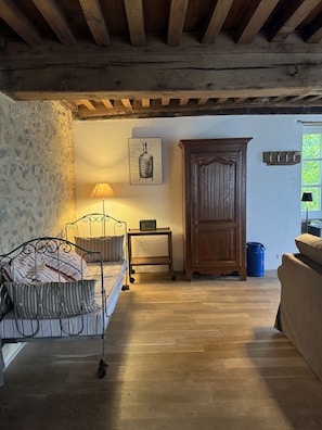 A bedroom with a bed, a wooden cabinet, a small table with a lamp, and a window with a view. - Holiday Home 'Gîte De Thivelle' with Private Garden and Wi-Fi (Cussy-en-Morvan)