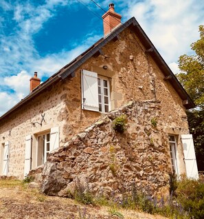 A stone house with a steeply pitched roof, white shutters, and a chimney. - Holiday Home 'Gîte De Thivelle' with Private Garden and Wi-Fi (Cussy-en-Morvan)