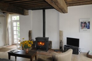 A room with a fireplace, a sofa, a table, and a window. - Holiday Home 'Gîte De Thivelle' with Private Garden and Wi-Fi (Cussy-en-Morvan)
