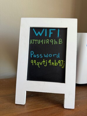 A white chalkboard sign with 'WIFI' and 'Password' written on it.