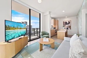 Un apartamento moderno con balcón amplio, televisor de pantalla plana, comedor y cocina.