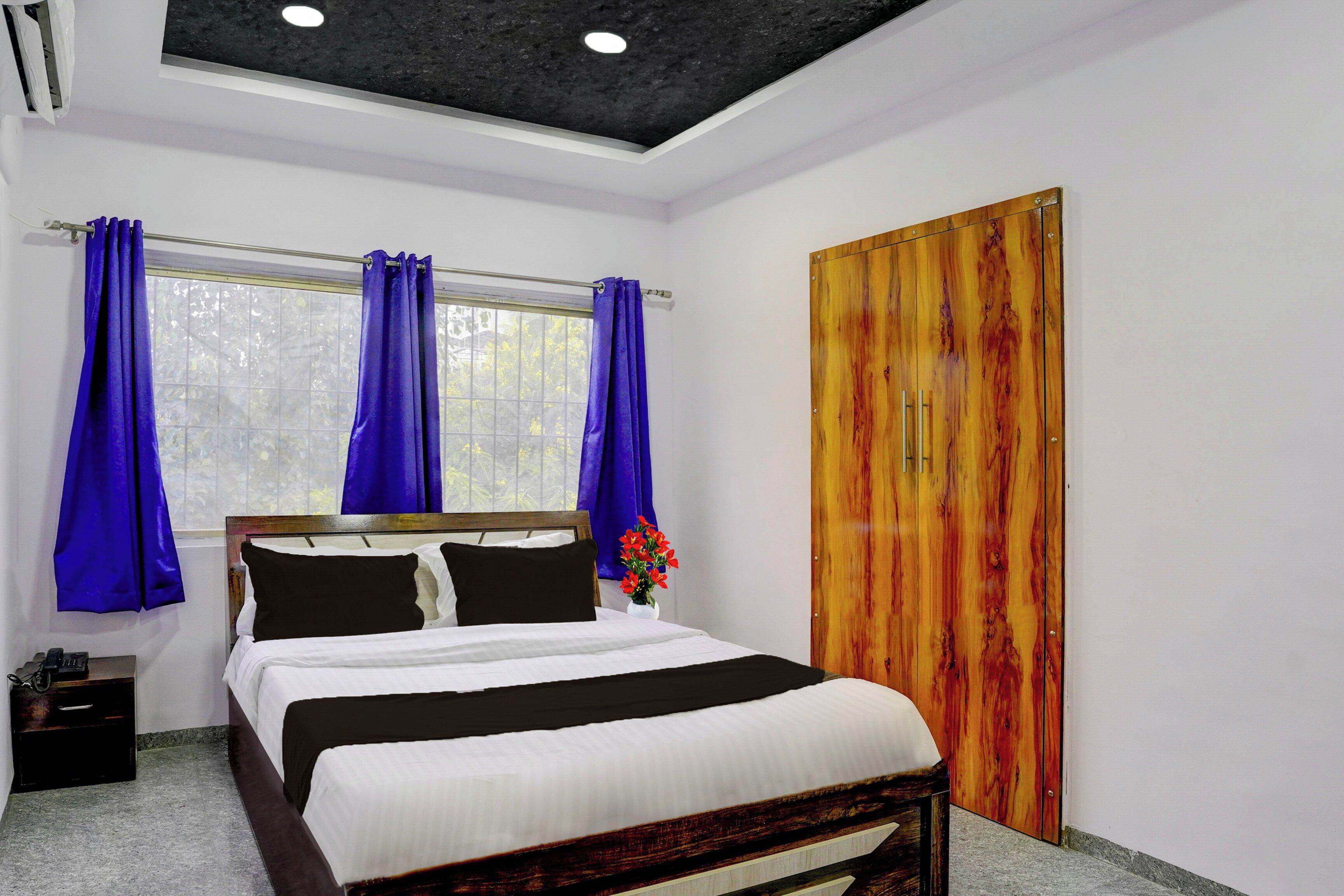 Un dormitorio con cama, cortinas, una puerta de madera y una ventana.