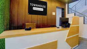 Una mesa de recepción con un cartel que dice 'TOWNHOUSE Company-Serviced' y una computadora.