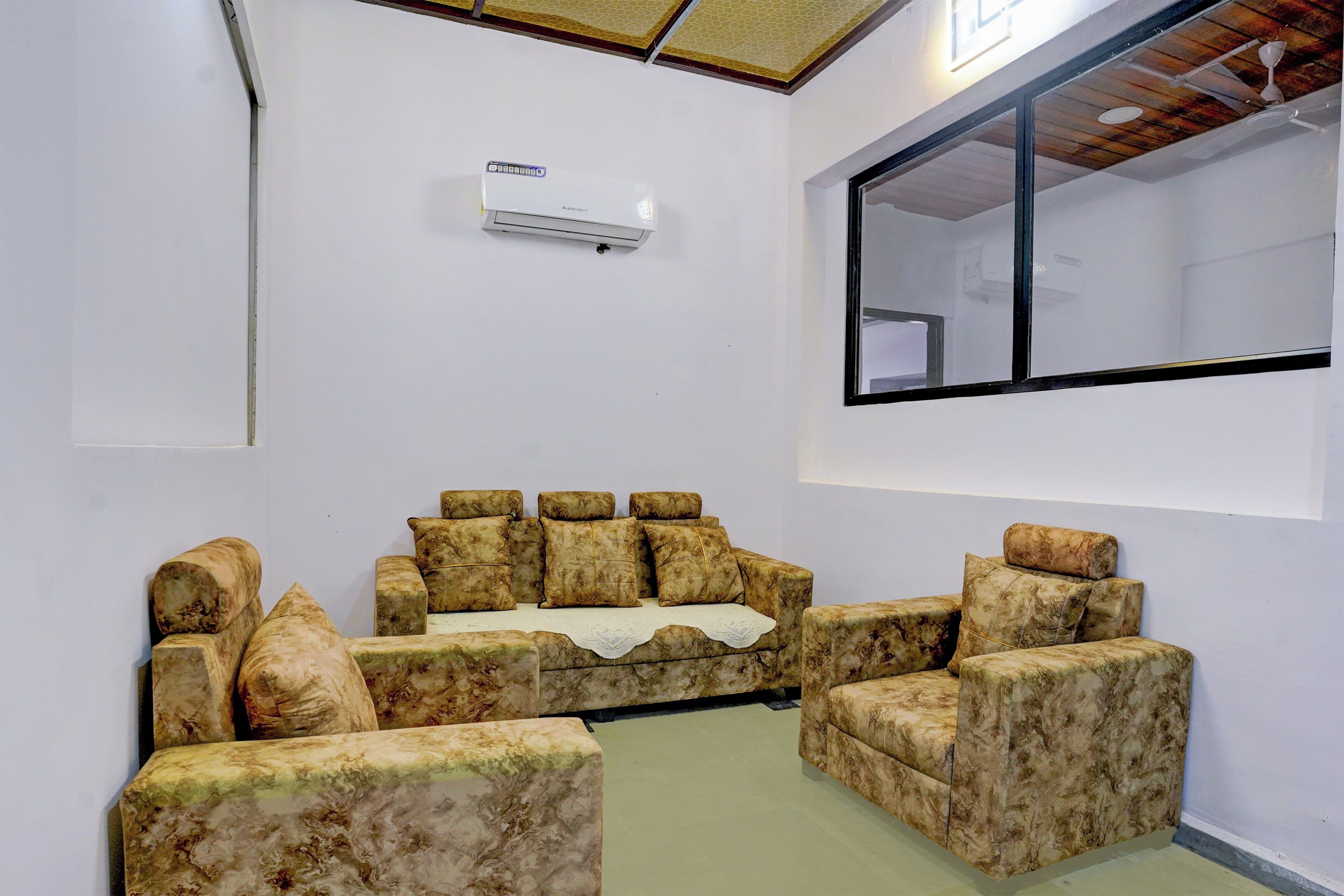 Una habitación con sofá, ventana y equipo de aire acondicionado.