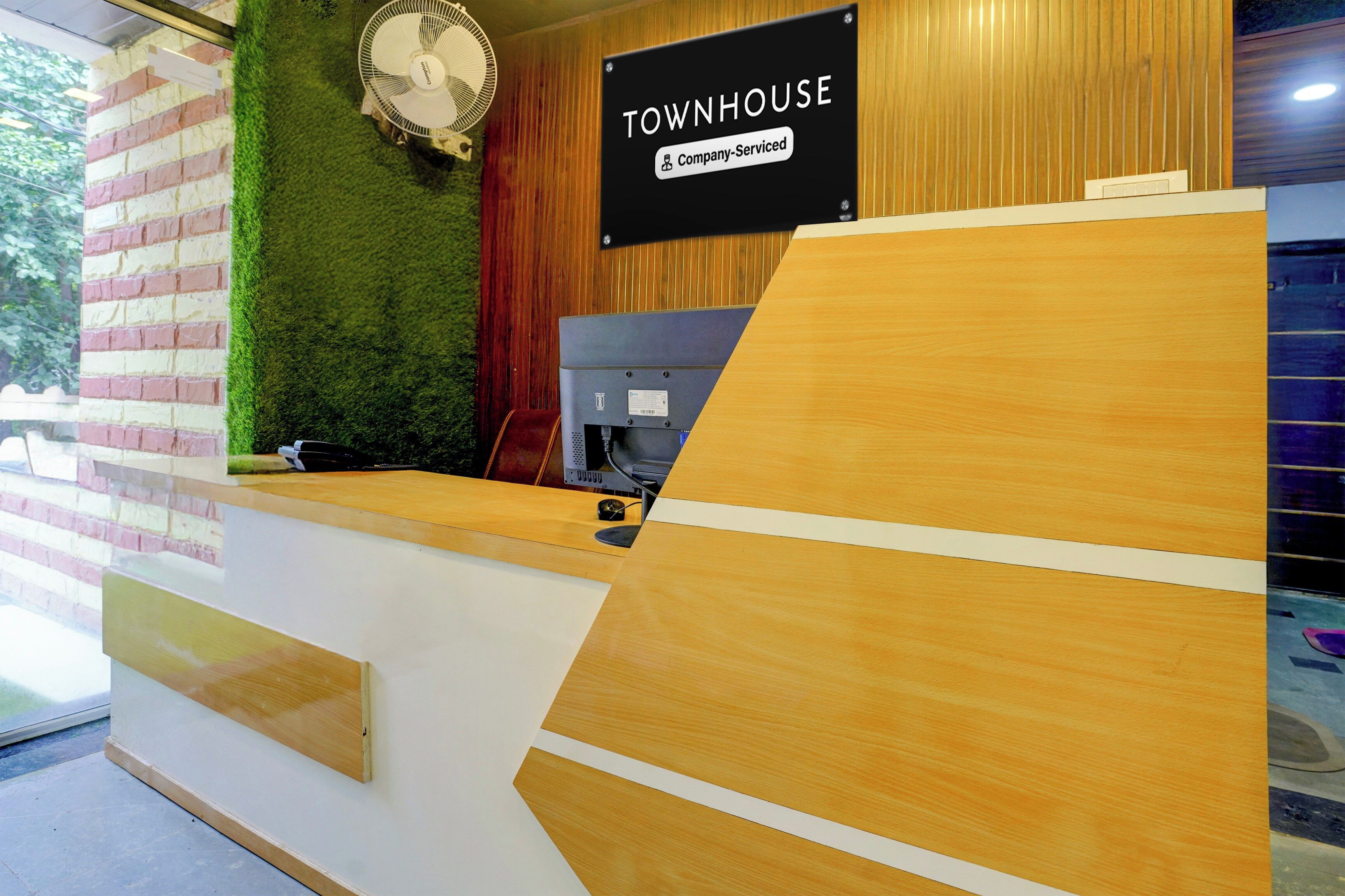 Un comptoir d’accueil avec une pancarte indiquant : « Services de la société TOWNHOUSE ».