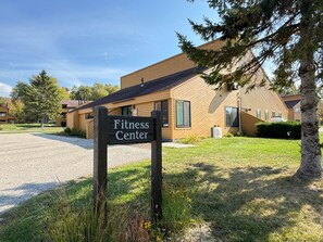 A building labeled 'Fitness Center' with a gravel driveway and surrounding greenery. - Northern Oasis near Nub's Nob (Pleasantview Township)