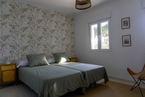 A bedroom with two beds, a window, and a chair. - Casa Perdiz, ideal choice for style and comfort (Conil de la Frontera)