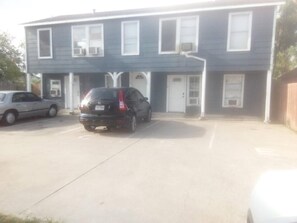 A two-story building with a garage parking area. - WESTSIDE 1-bedroom remodelded apt, AC, nice quartz counters- in Corpus Christi (Corpus Christi)