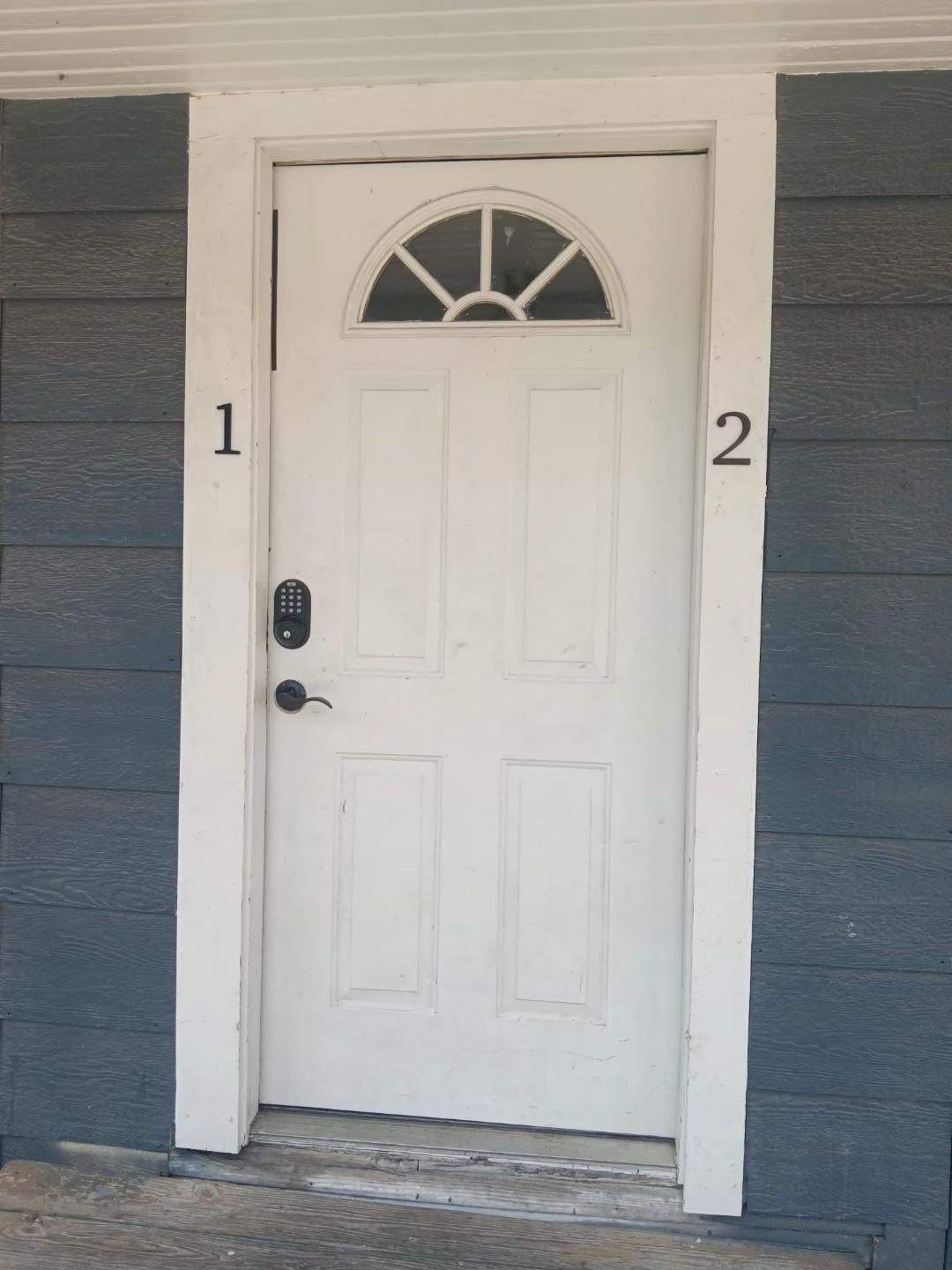 A white door with a small window above it, marked with the numbers 1 and 2 on either side.