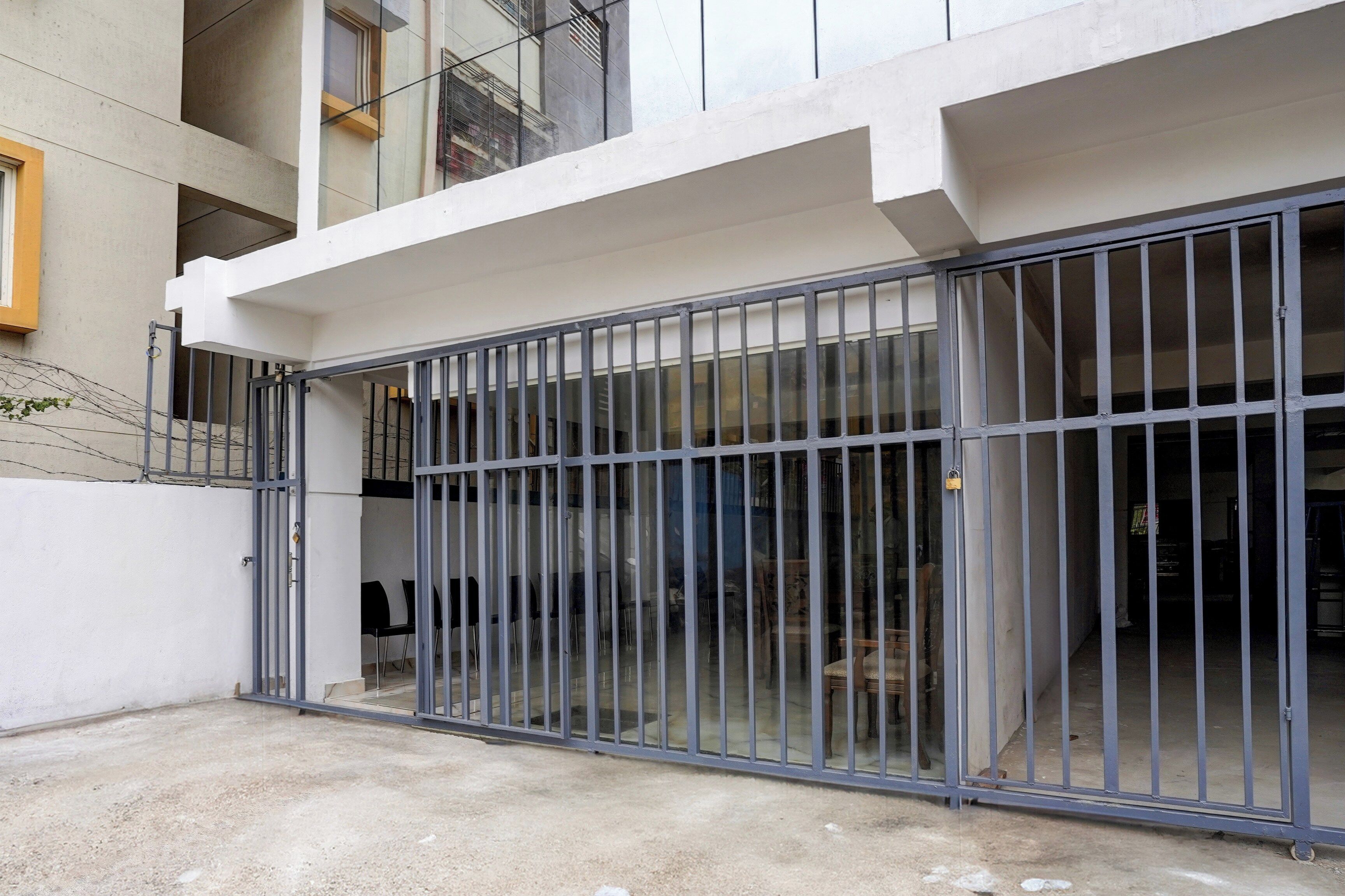 A gated entrance to a building with a concrete floor and a metal gate.