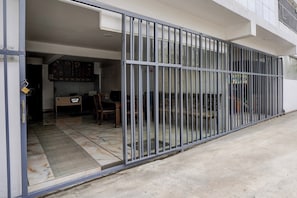 Een hotelentree met een metalen hek, een receptiebalie en een betegelde vloer.