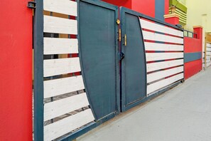 Una entrada protegida con una verja de metal y una cerca de madera.