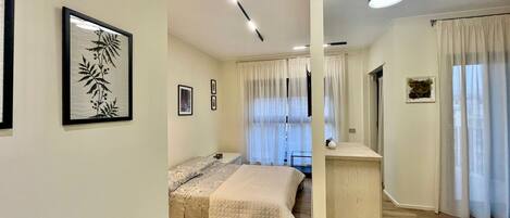 Un dormitorio con cama, escritorio y silla. Hay cortinas en las ventanas.