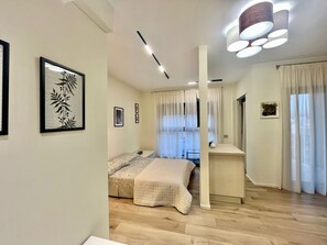 Un dormitorio con cama, escritorio y silla. Hay cortinas en las ventanas.