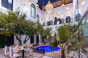 An indoor courtyard with a pool, seating area, and hanging chandeliers. - RYAD DOTTY (Marrakech)