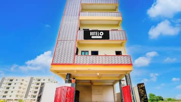 Un edificio de varios pisos con un cartel llamativo que dice 'HOTEL' en el segundo piso.