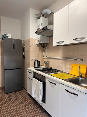 A compact kitchen with a refrigerator, stove, sink, and cabinets. - New Listing (Venezia)