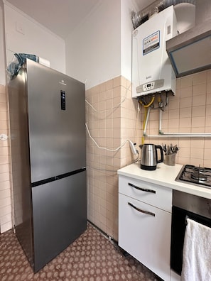 A kitchen with a stainless steel refrigerator, a gas stove, and a built-in oven. - New Listing (Venezia)
