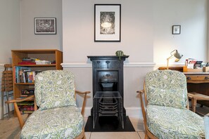 A room with two patterned armchairs, a bookshelf, a fireplace, and a framed picture on the wall. - Spacious 4 Bed Edwardian London Home with Garden - Pass the Keys (London)