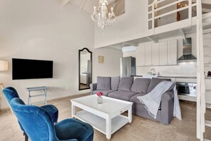 A modern living room with a sofa, a coffee table, and a TV. - 2BR Duplex, Marina View, Sleeps 6 · Apt 15 Ocean Breeze (Kralendijk)