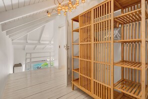 A room with a wooden wardrobe, a ceiling light fixture, and a view through an open door. - 2BR Duplex, Marina View, Sleeps 6 · Apt 15 Ocean Breeze (Kralendijk)