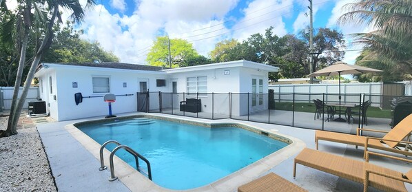 A residential swimming pool with a fenced deck, a basketball hoop, and outdoor furniture. - Pool Home w/ 2 Kings near Beach, FLL & Hard Rock (Hollywood)