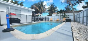 A swimming pool with a fence, lounge chairs, and a barbecue area. - Pool Home w/ 2 Kings near Beach, FLL & Hard Rock (Hollywood)