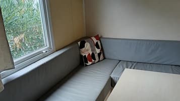 Ein Zimmer mit eingebautem Sitzplatz, einem Tisch und einem Fenster.