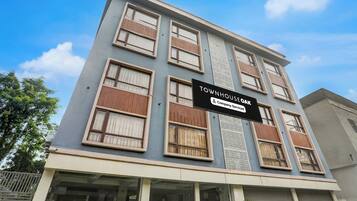 Un edificio de varios pisos con un letrero que indica 'TOWNHOUSE OAK' y alojamiento con servicios de empresa.