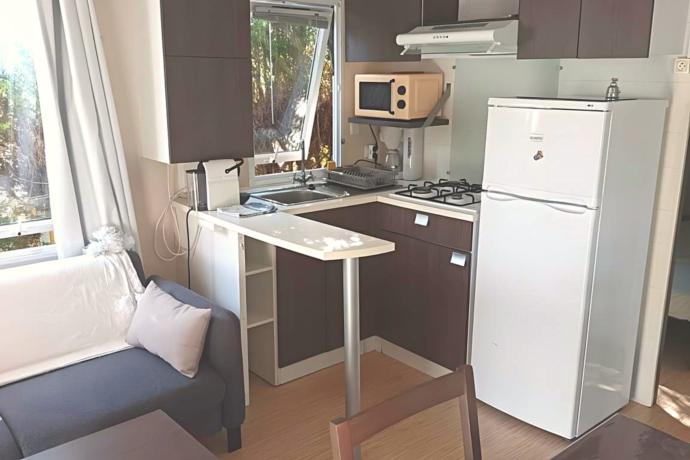 Une petite cuisine équipée d’un four à micro-ondes, d’une cuisinière et d’un réfrigérateur.
