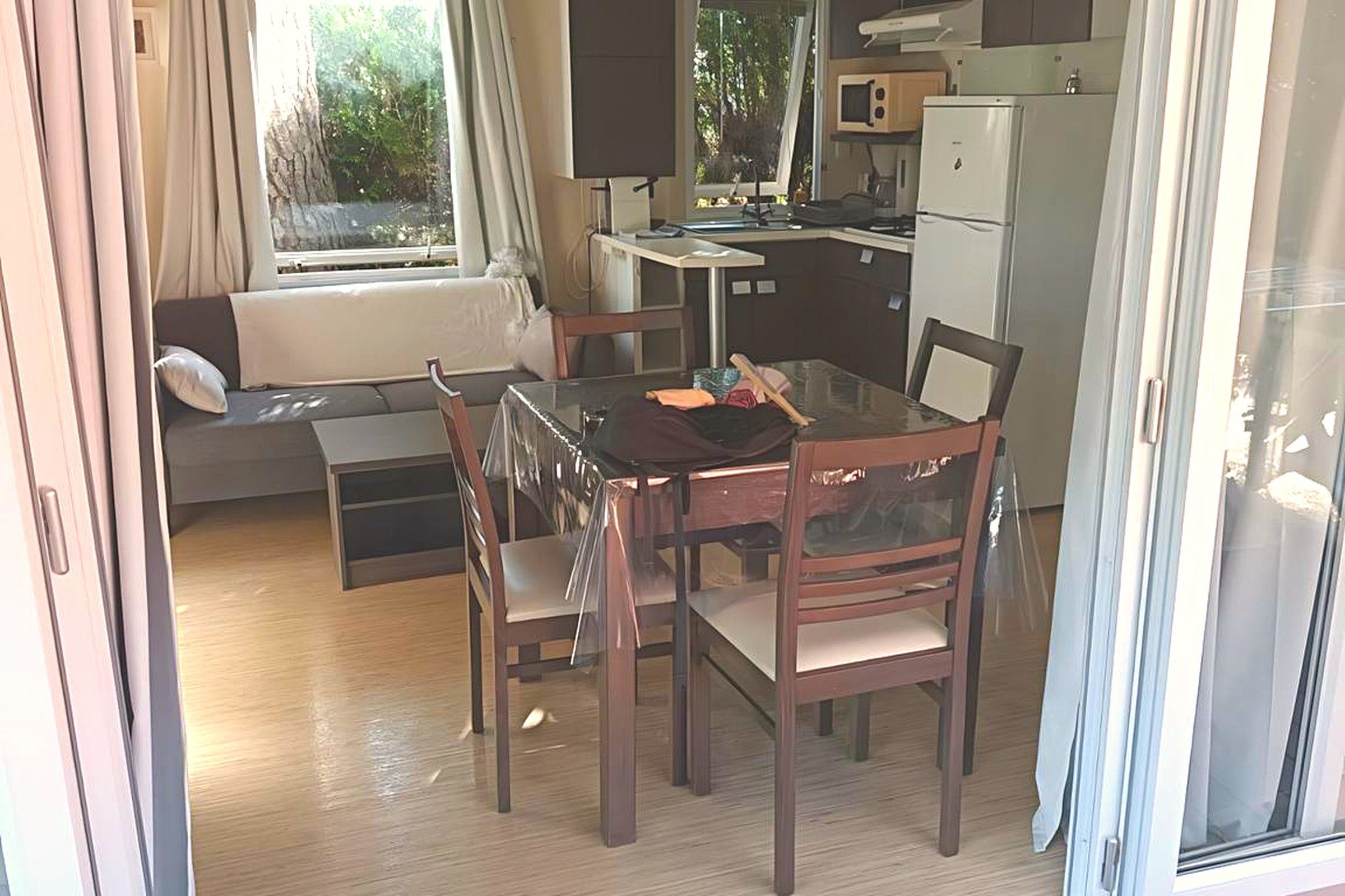 Un espace de vie compact comprenant une kitchenette, un coin repas et un canapé.