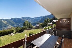 A terrace with a table and chairs, overlooking a mountainous landscape. - App. La Forêt 43 - Two Bedroom Apartment, Sleeps 5 (Riddes)
