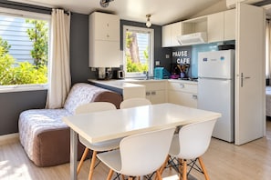 A compact kitchen with a dining area, a built-in oven, and a refrigerator.