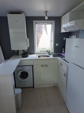 A compact kitchen with a washing machine, a sink, and a refrigerator. - Mobile Home 'Mobil-home Piscine, Clim Et Wifi' with Shared Pool, Wi-Fi and Air Conditioning (Argelès-sur-Mer)