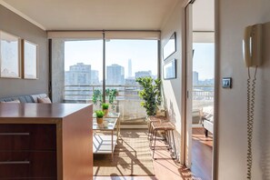 A modern apartment with a balcony, a dining area, and a view of the city skyline. - Chic Providencia Apt Cozy Stay Ideal for 3 Guests (Providencia)