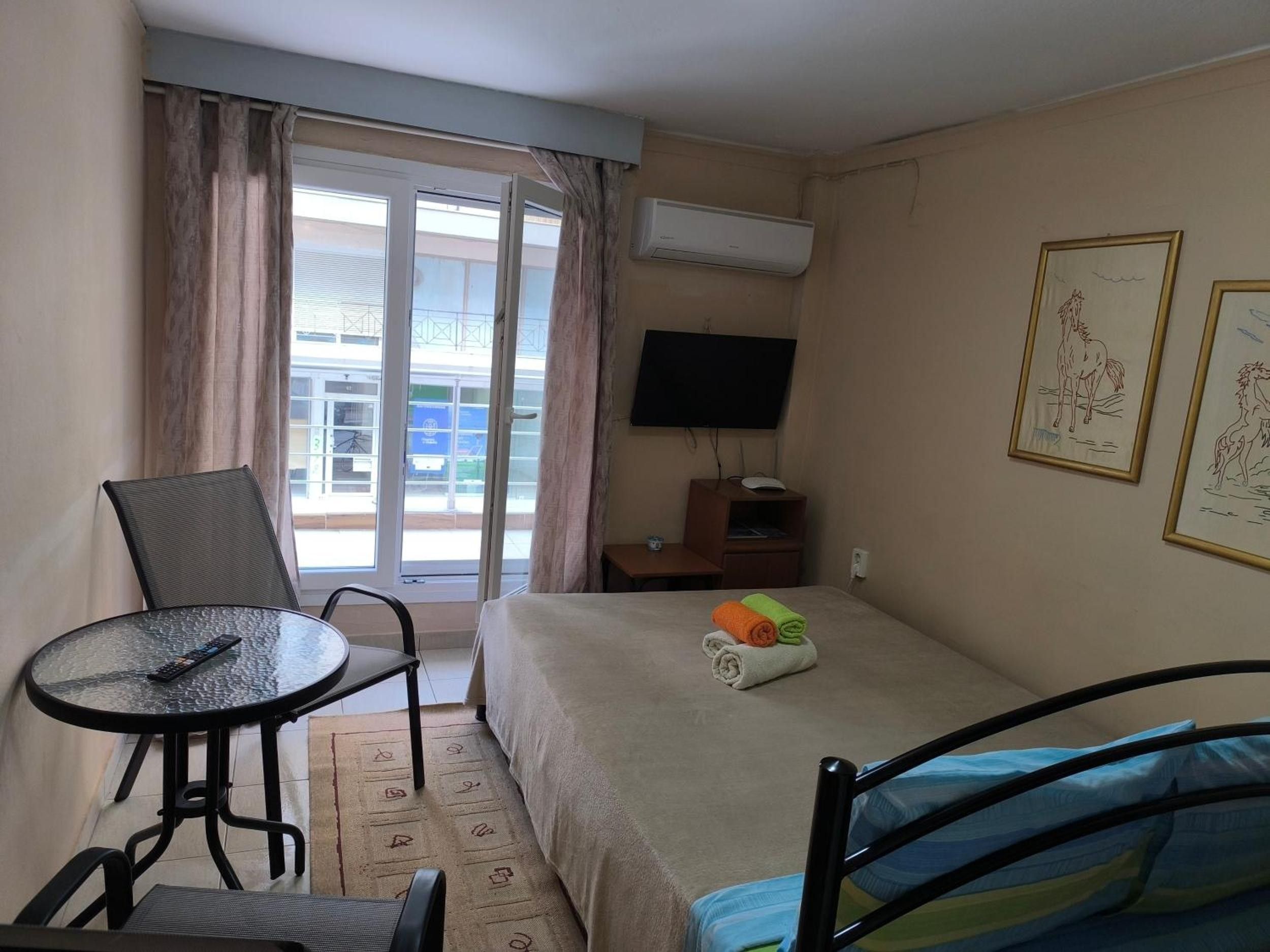 Une chambre d’hôtel équipée d’un lit, d’un bureau, d’une chaise, d’une télévision et d’une fenêtre avec des rideaux.
