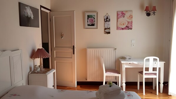Ein Schlafzimmer mit einem Bett, einem Nachttisch, einer Lampe und einem Schreibtisch mit Stuhl.