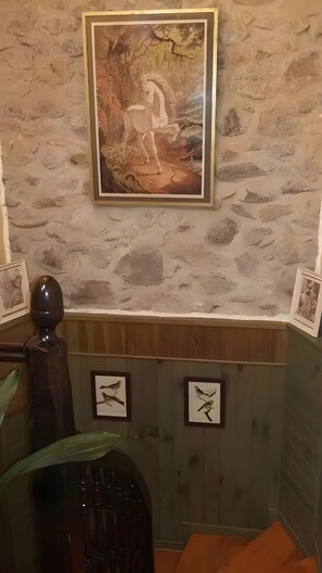 A room with a stone wall, a framed painting of a horse, and two framed bird pictures. - Bed and Breakfast 'Chambre Colombe' with Shared Terrace, Shared Garden and Wi-Fi (Belvianes-et-Cavirac)