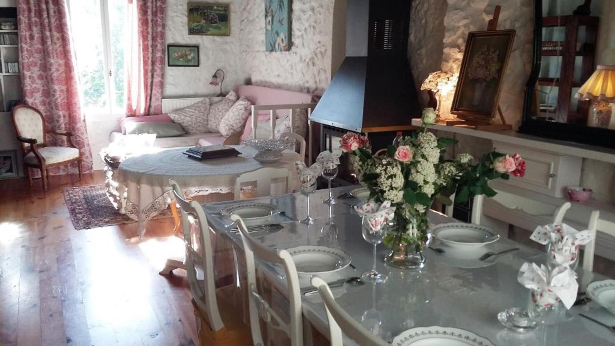 Un coin repas avec une table dressée pour quatre personnes, entourée de chaises.