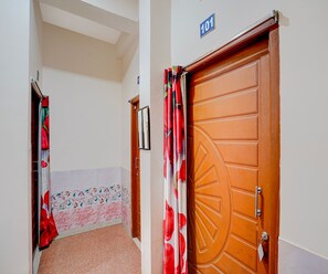 A hallway with a door marked '101' and a door with a geometric pattern. - Deluxe Hotel Sunshine (Gop)