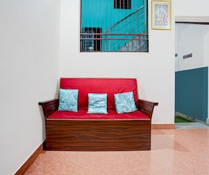A wooden sofa with red cushions and blue patterned pillows in a hallway. - Deluxe Hotel Sunshine (Gop)