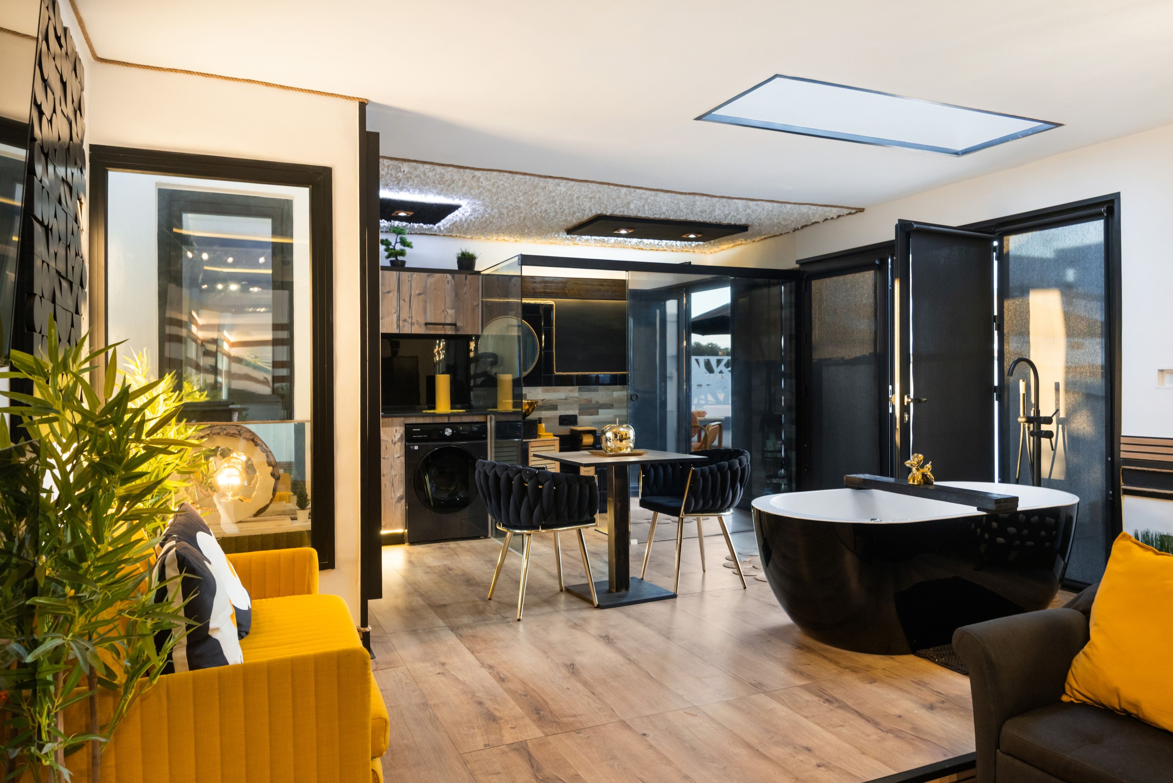 Eine moderne Küche mit Essbereich, einer Waschmaschine und einem großen Fenster.