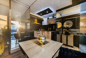 Una cocina moderna con encimera de madera, una mesa de comedor de vidrio y vistas al exterior.