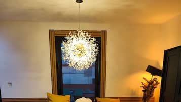 A bedroom with a bed, a bedside lamp, a window, and a decorative plant.
