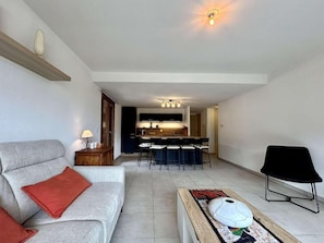 A modern living room with a sofa, a coffee table, and a dining area with chairs. - 3rd floor, view panoramic, terrace, tv, 68m², Serre Chevalier (Briançon)