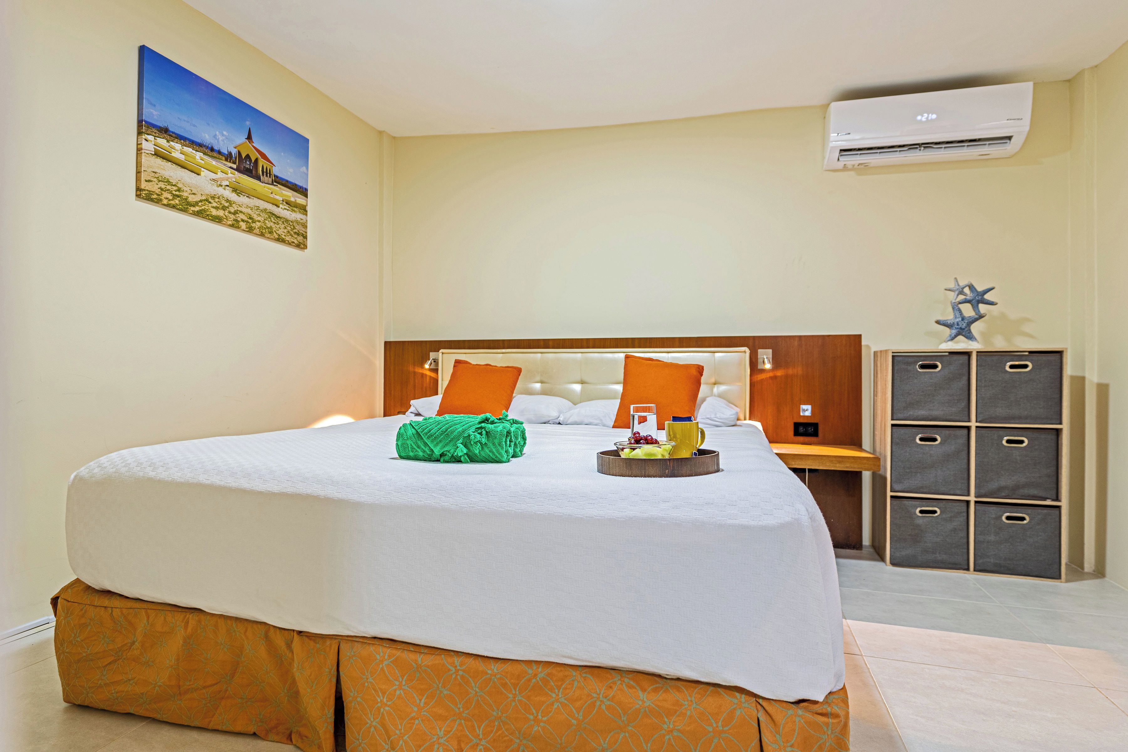 Ein Hotelzimmer mit Bett, Nachttisch, Kleiderschrank und Klimaanlage.