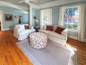 A living room with two sofas, a patterned ottoman, a lamp, and a ceiling fan. - Fabulous 2-bedroom house in charming Jacksonville Oregon (Jacksonville)